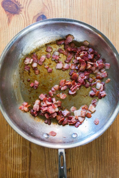 Golden, crisp sautéed guanciale in a skillet.