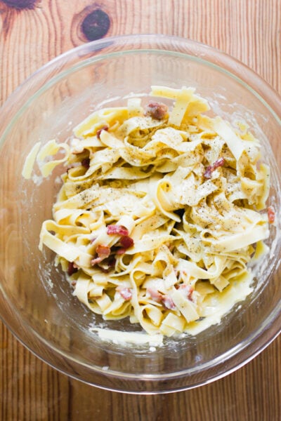 Tossing fresh homemade pasta with carbonara sauce