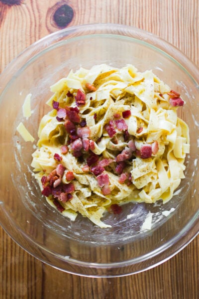 Fresh pasta and crisp guanciale in the egg mixture bowl