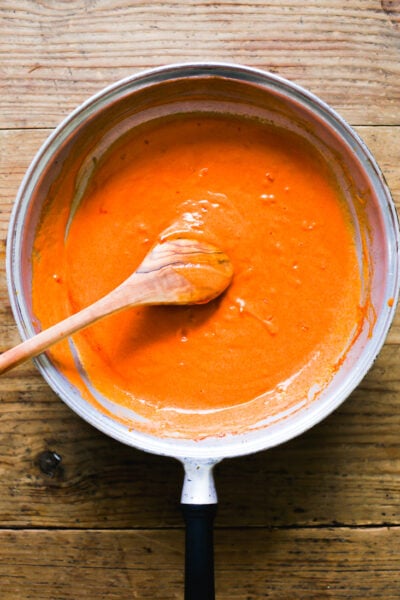 Cooked tomato paste with pasta cooking water in a pan
