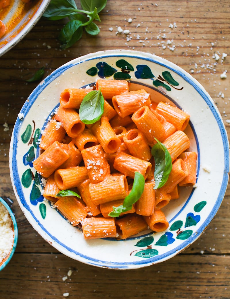 Rigatoni pasta with vodka sauce in a bowl with fresh basil and Parmesan cheese