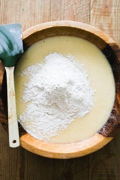 Sugar, oil, eggs, vanilla extract & sourdough starter whisked together in a wooden bowl with the flour and other dry ingredients