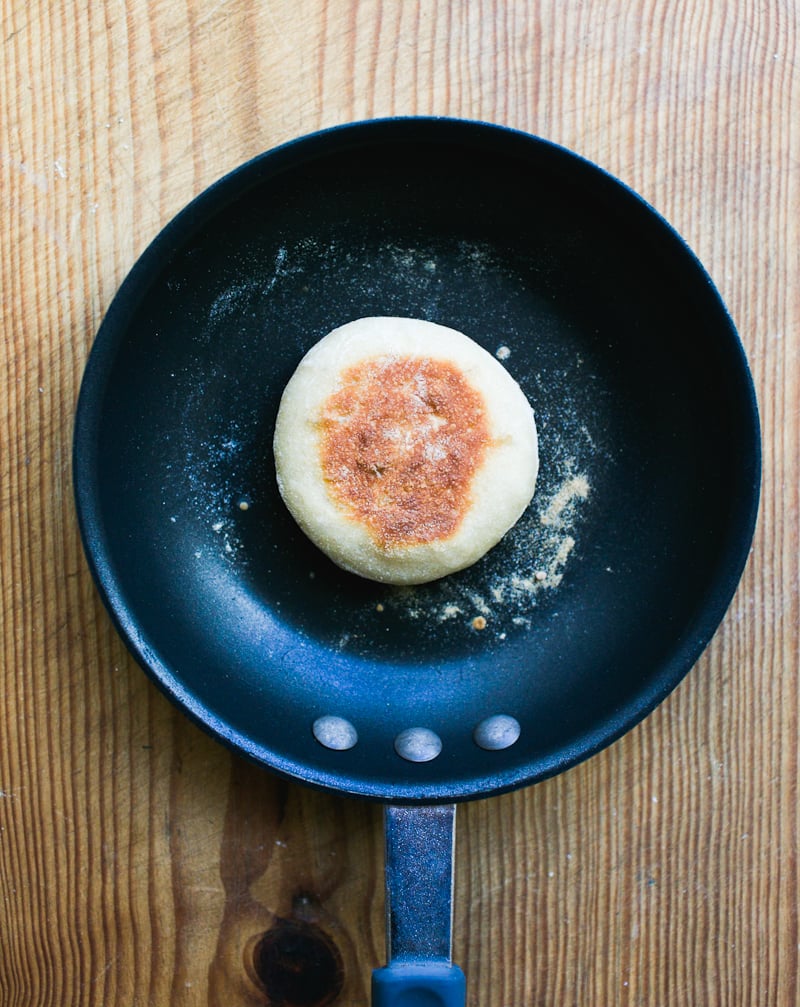Cooked sourdough English muffin in a black, non-stick skillet