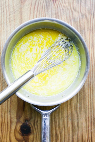 Milk, water and melted butter in a pan with a wooden spoon