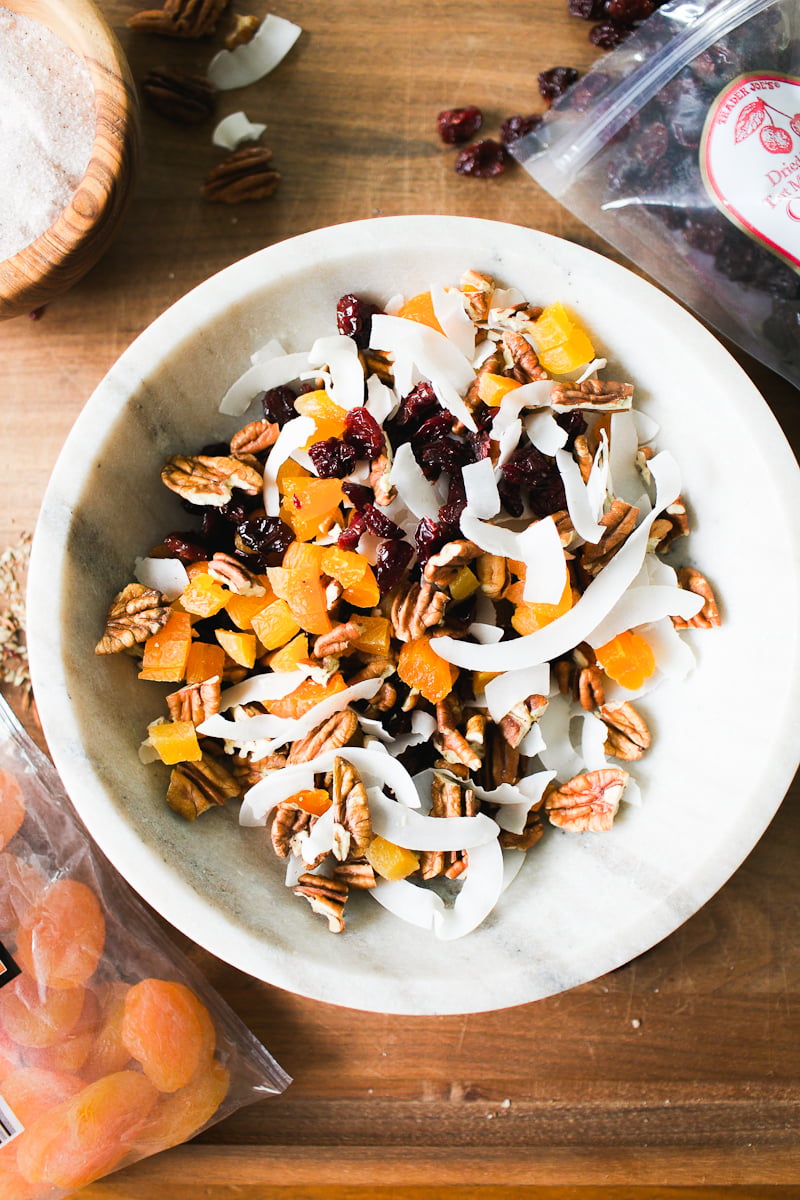 Mixed dried fruit, coconut flakes, and nuts in a marble bowl for sourdough granola