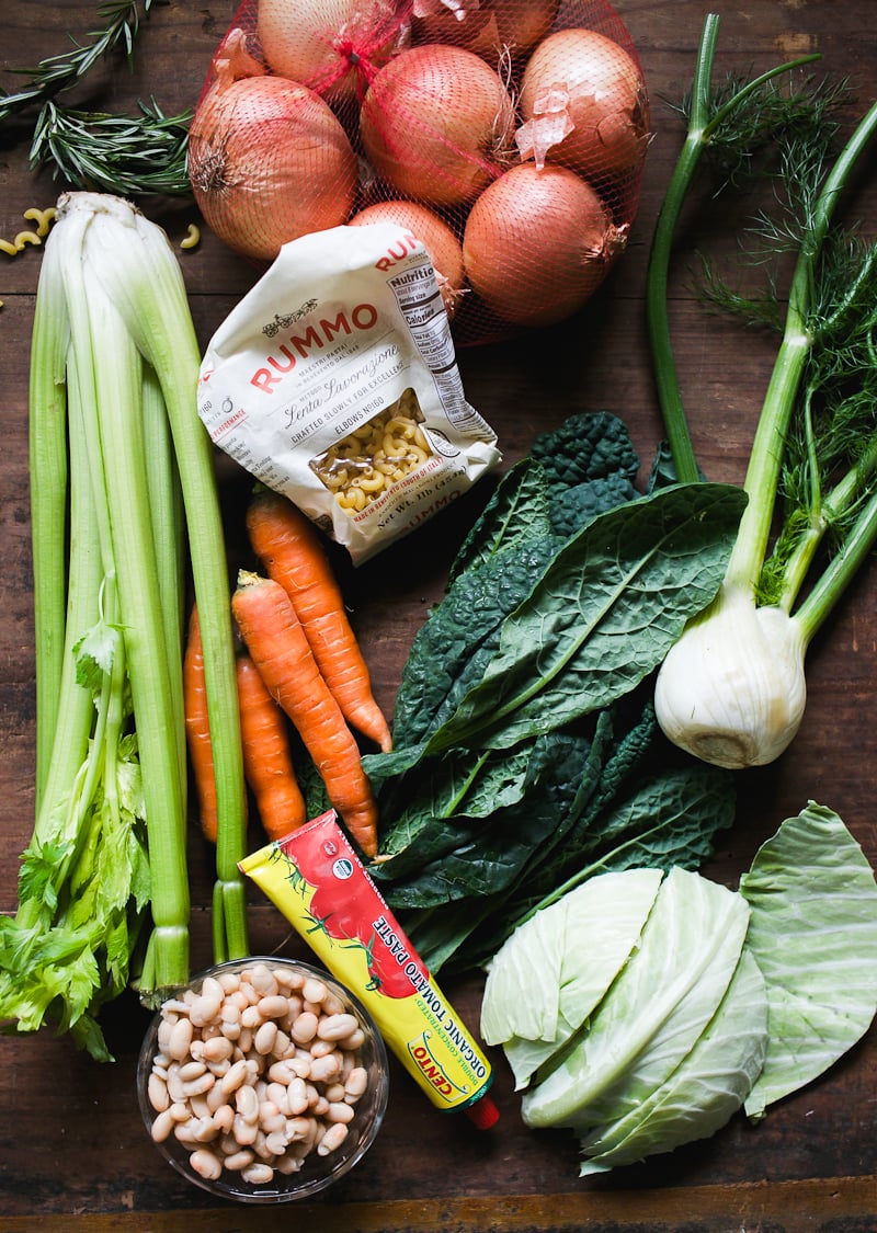 Italian minestrone soup ingredients: carrots, onion, celery, garlic, fennel, Tuscan kale, cabbage, white beans, rosemary and tomato paste