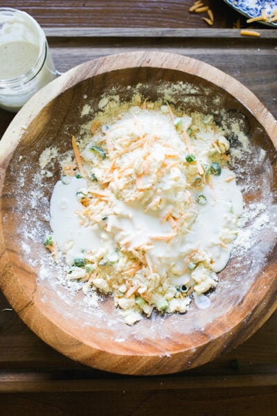 Sourdough starter mixture added to biscuit dough mixture in a large wooden bowl