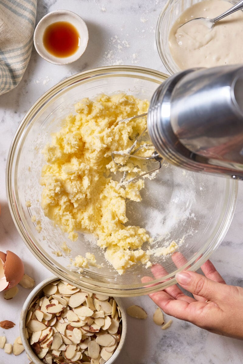 Glass mixing bowl with butter and sugar, creamed by hand with a hand held electric mixer.