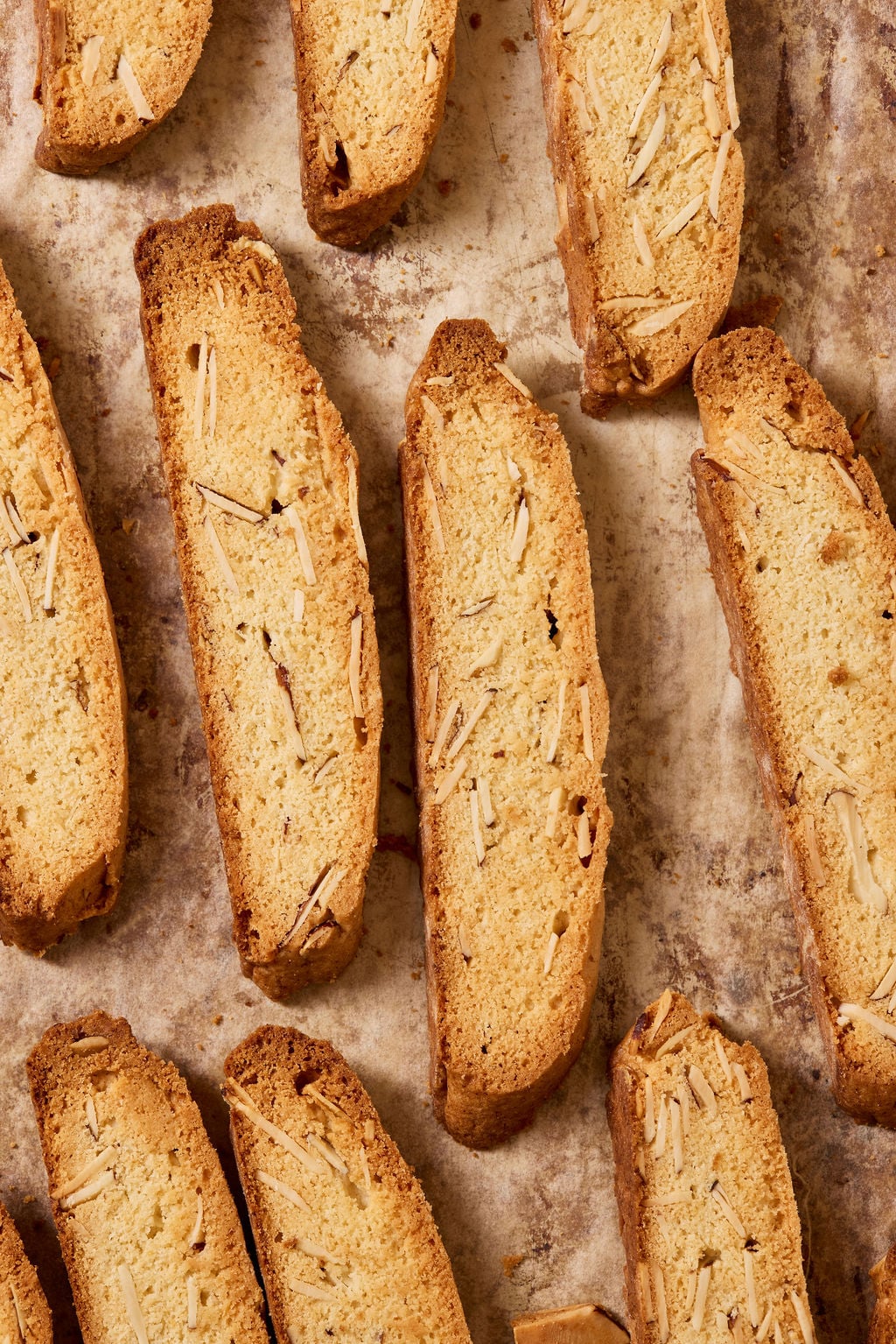 Sourdough biscotti with almonds on a parchment lined sheet pan.