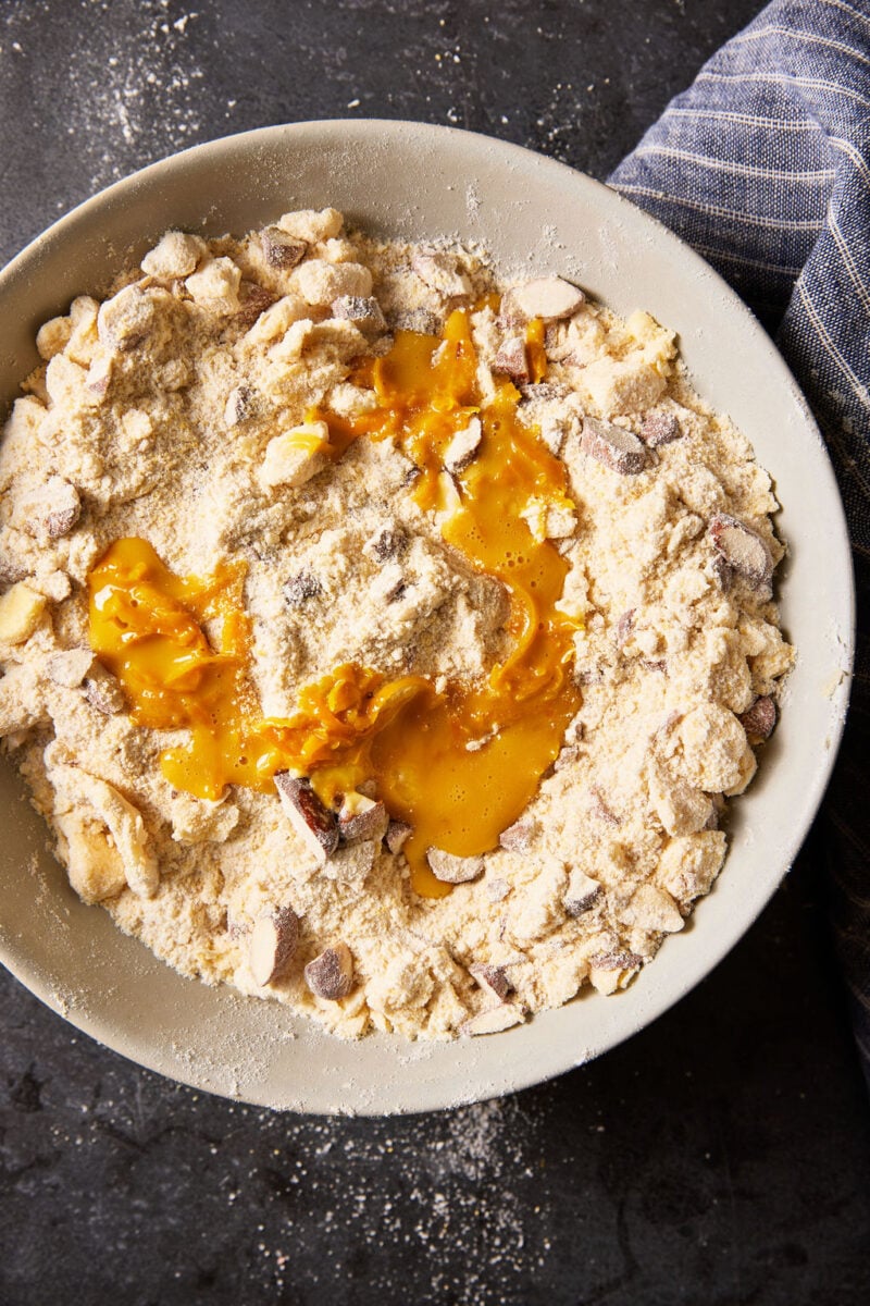 Egg yolk mixture on top of the flour mixture, tossed with sugar and chopped almonds.