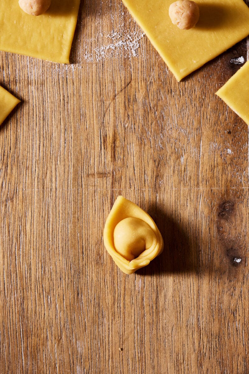 Finished shaped sourdough tortellino on a wooden surface.