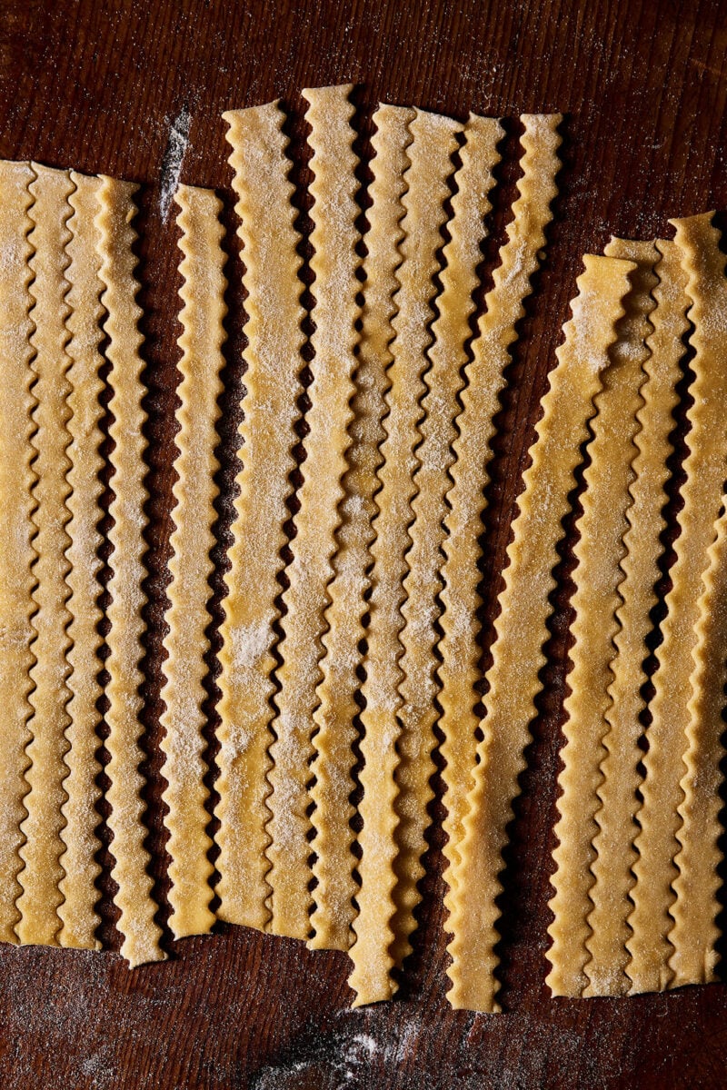 Hand-cut sourdough mafaldine pasta on a wooden surface