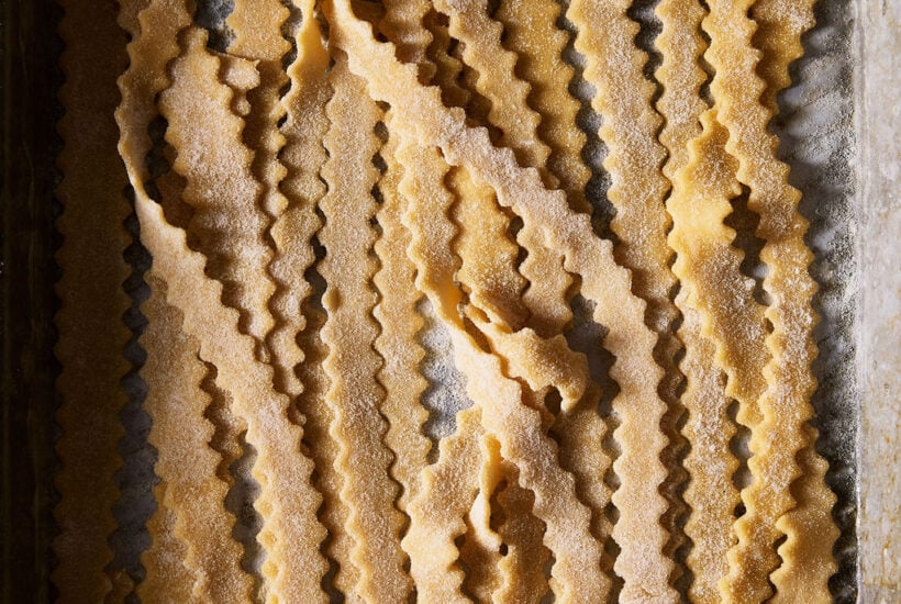 Hand-cut sourdough mafaldine on a sheet pan