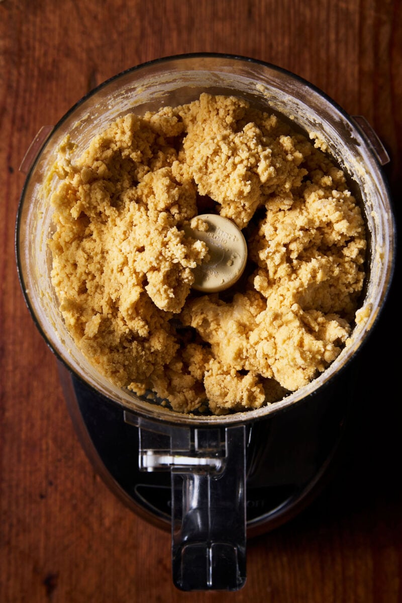 Crumbly sourdough mafaldine pasta dough in a food processor
