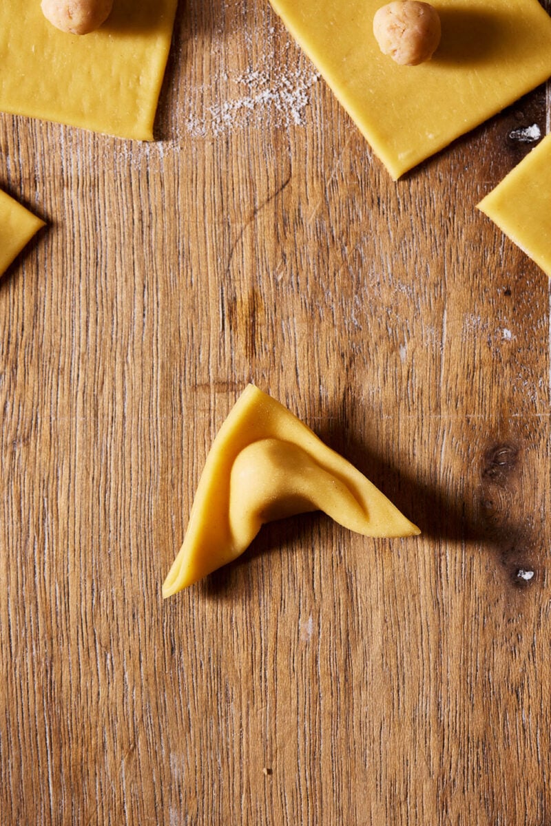 Folded sourdough tortellini with an indent in the center of the filling.