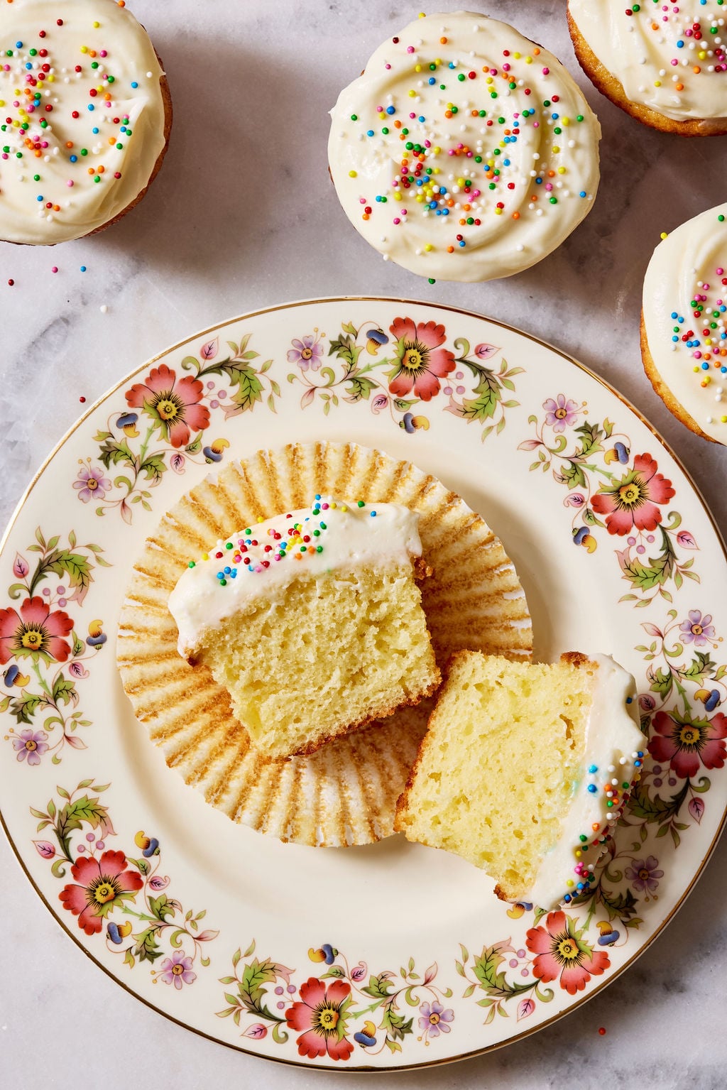 Sourdough cupcake, halved, showcasing a moist and fluffy interior crumb, set on a flowered plate.